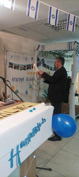 Tzevy Mirkin lightening Hanukkah candle (photo credit: MFA) Tzevy Mirkin lightening Hanukkah candle