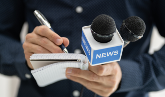 Closeup on a journalist holding a microphone